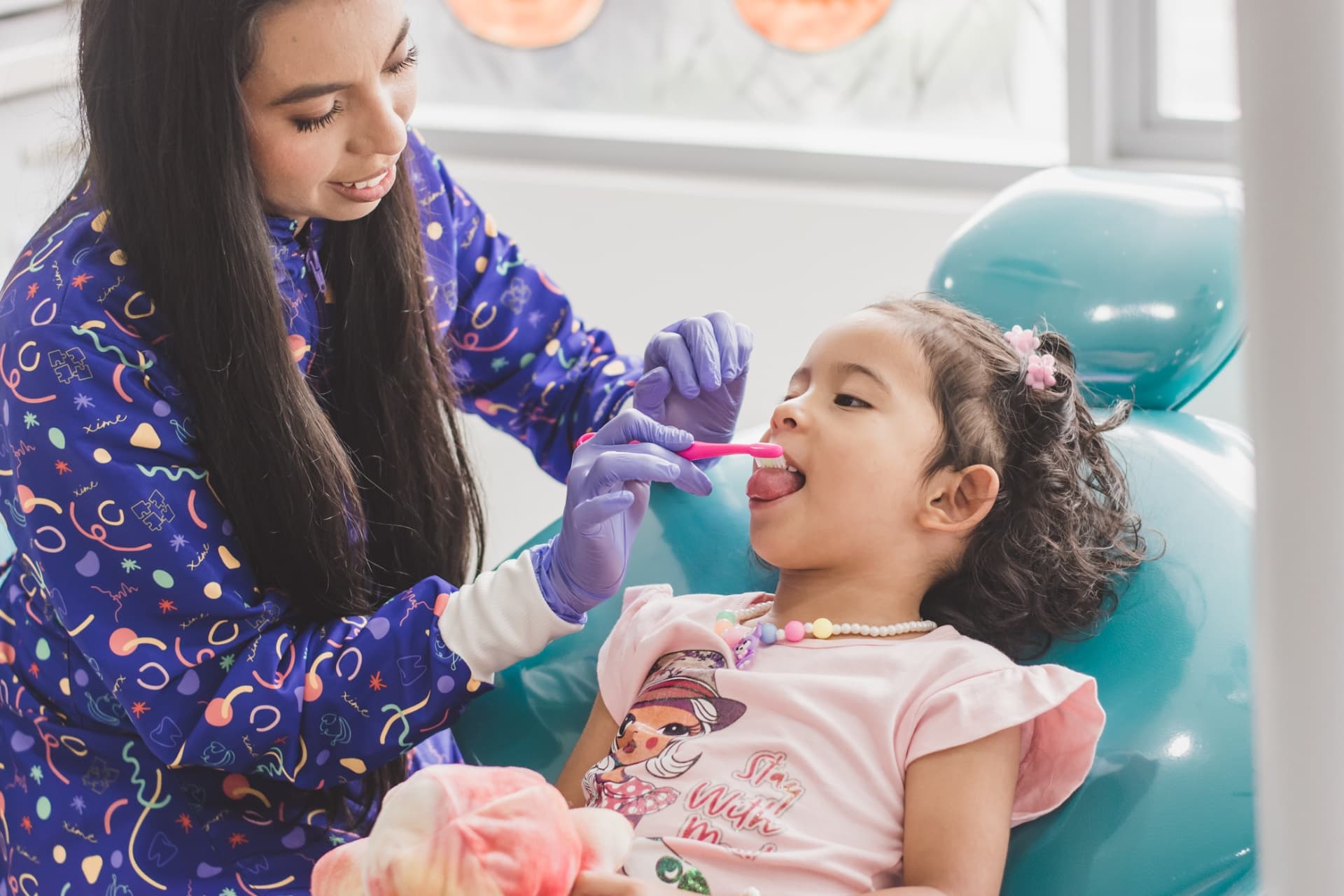 Dra. Ximena realizando atención dental a niña feliz en Medellín